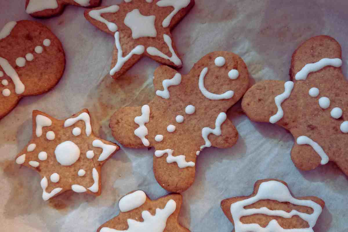 gingermanbread e altri biscotti glassati di natale disposti su una teglia da forno
