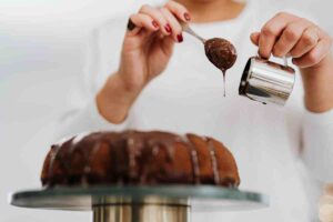 pasticcere che fa colare la glassa sul dolce con un pentolino